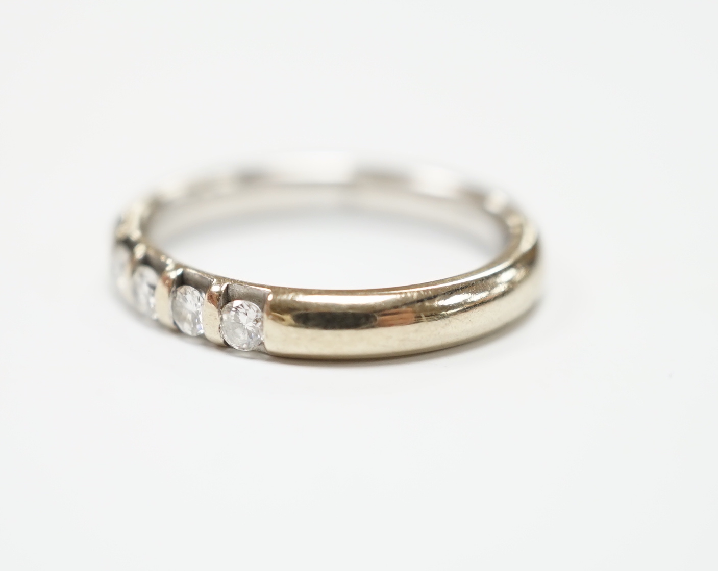 A modern 18ct white gold and five stone diamond set half hoop ring, size J, gross weight 3.6 grams.